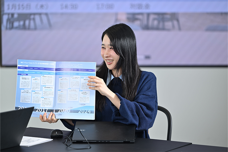 主要プロジェクトの紹介ページを紹介する永見佳子氏の写真