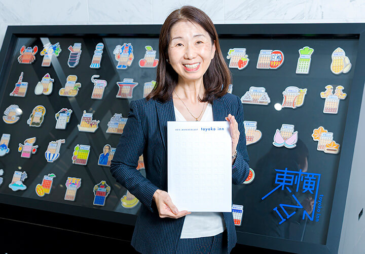 記念誌を持つ荻久保美紀氏の写真